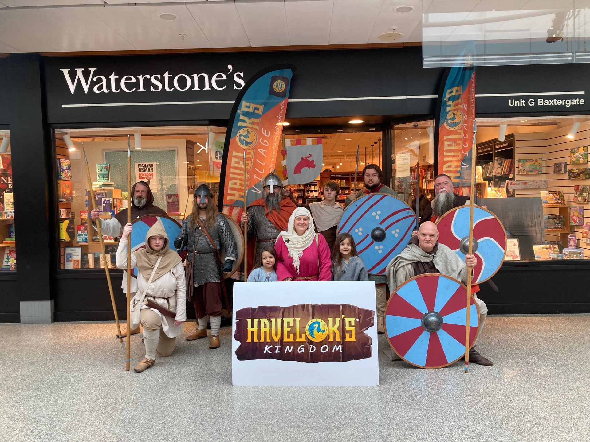 A group of people dressed as vikings are standing in front of a store.
