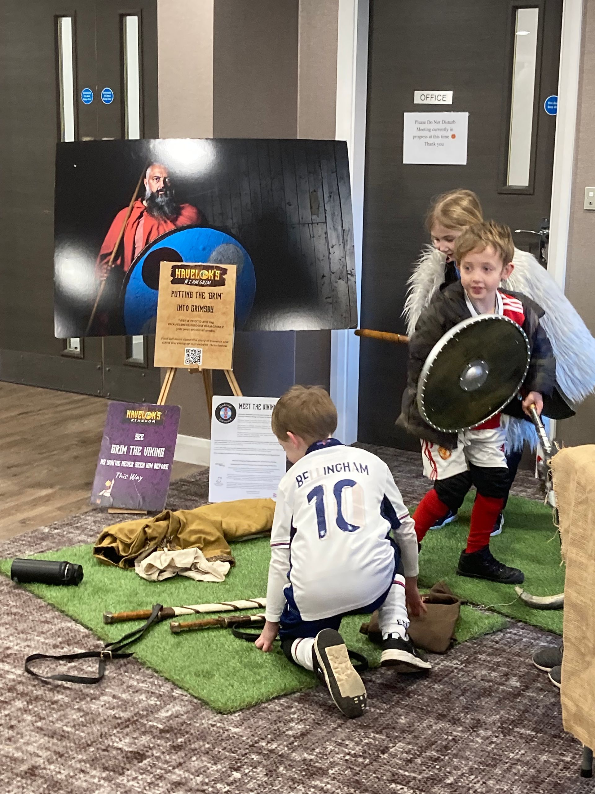 A group of children dressed up as vikings are playing with swords and shields.