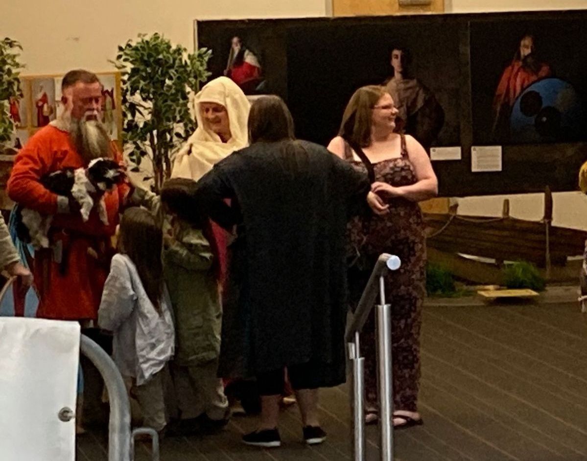 A group of people standing in front of a painting