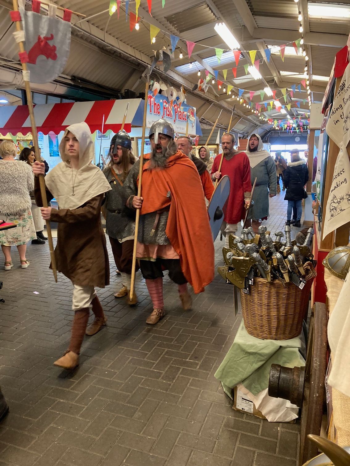 A group of people dressed in medieval costumes are walking down a street.