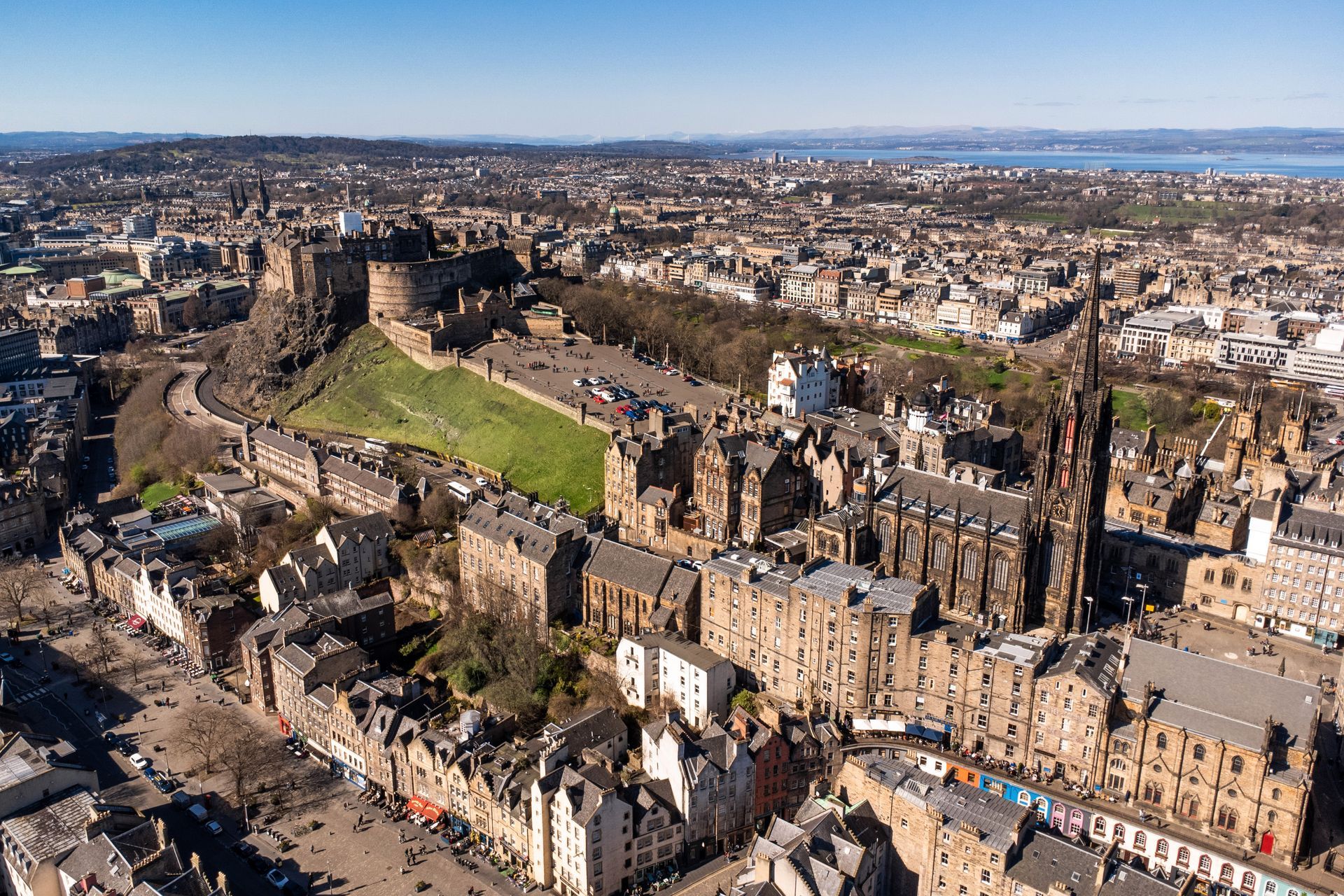 Aerial view of Edinburgh, Scotland, with Edinburgh Castle on a hill, buildings, and a church.