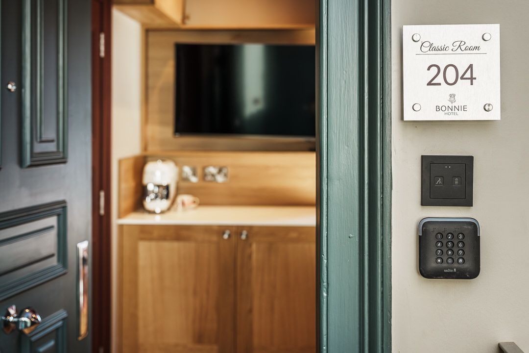 Doorway of hotel room 204 with keycode pad and light switch.