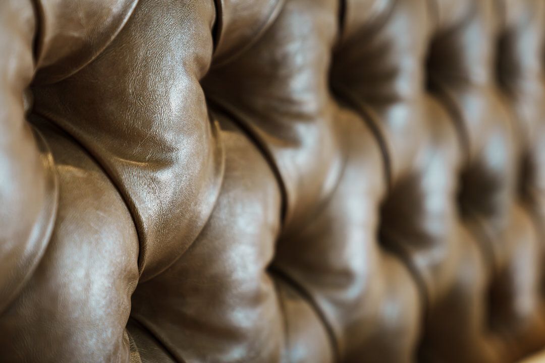 Close-up of brown, tufted leather upholstery.