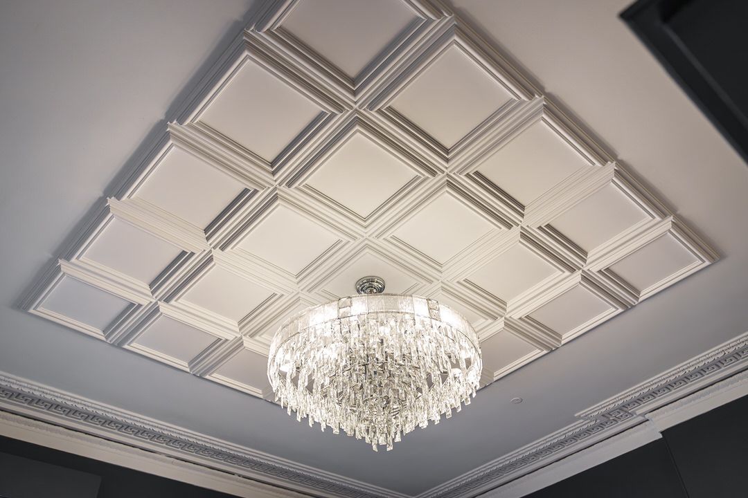 Ornate white ceiling with diamond pattern and crystal chandelier.