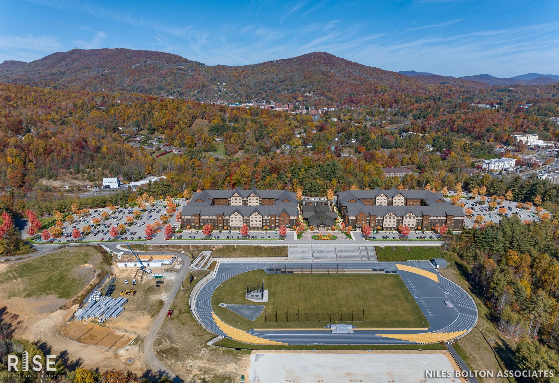 Photo of housing next to a sporting field with hills in the background