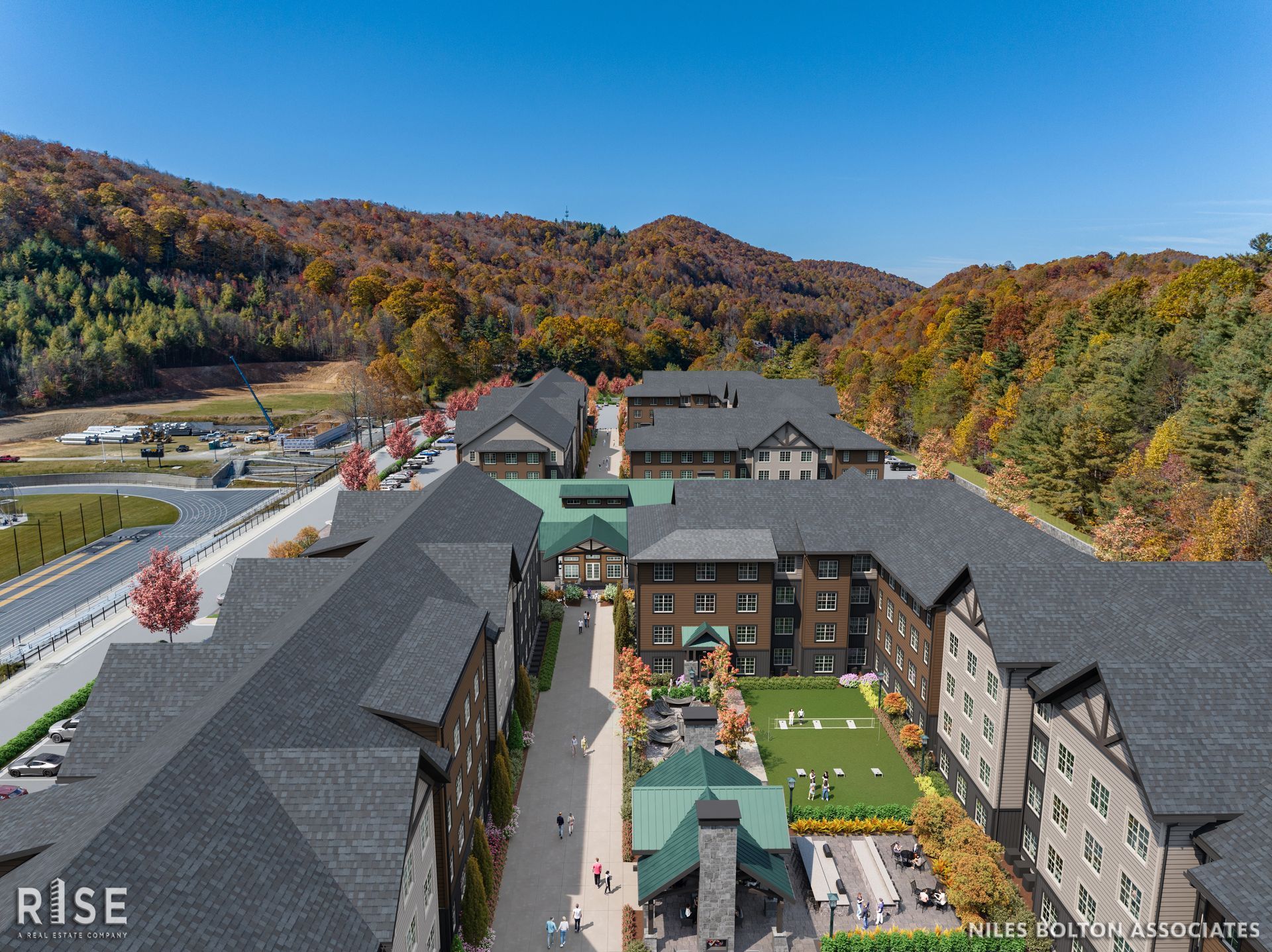 Photo of multiple buildings in a valley-like setting, with tree-lined hills surrounding