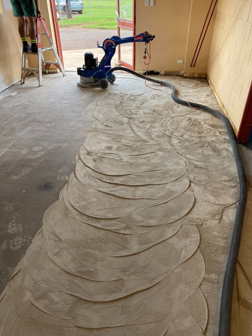 A person is standing on a ladder in a room with a machine on the floor — Local Builders in Yarrawonga, NT