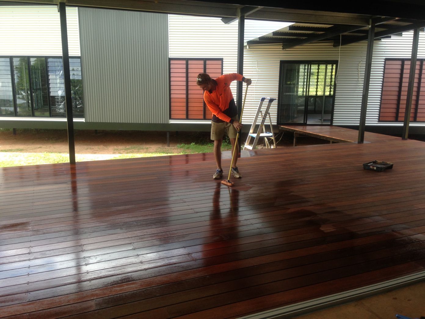 A man in an orange shirt is standing on a wooden deck — Local Builders in Yarrawonga, NT