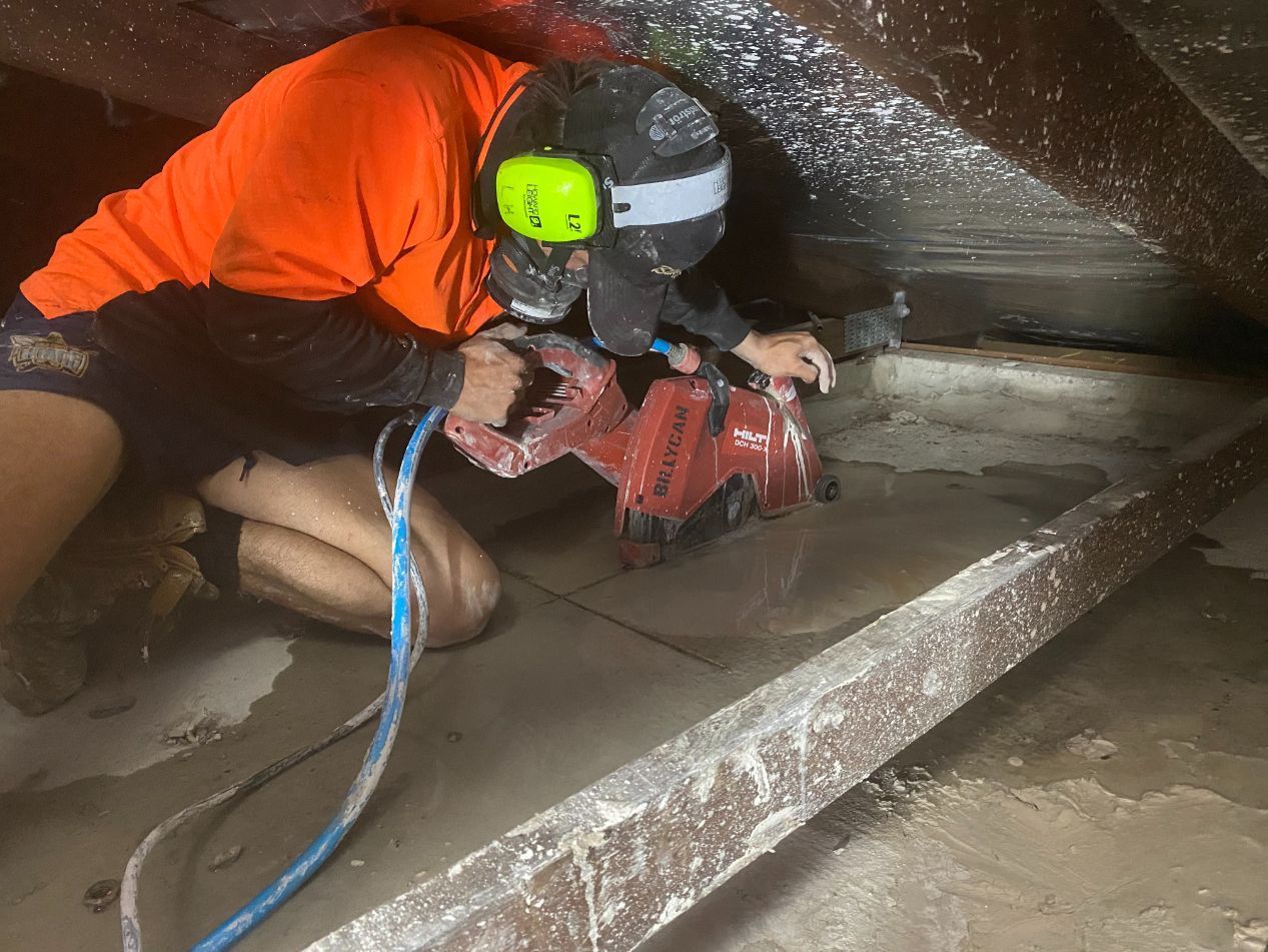 A man is kneeling on the floor using a machine — Local Builders in Yarrawonga, NT