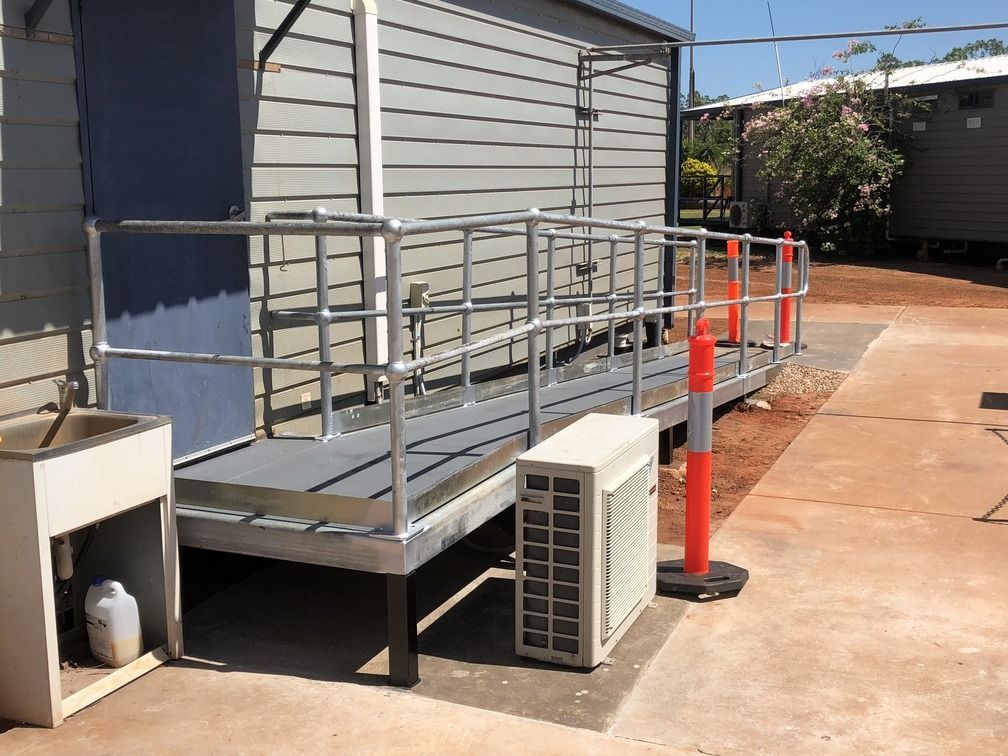 A Concrete Walkway is Being Built Next to a Building — Commercial Shop Fitout in Yarrawonga, NT