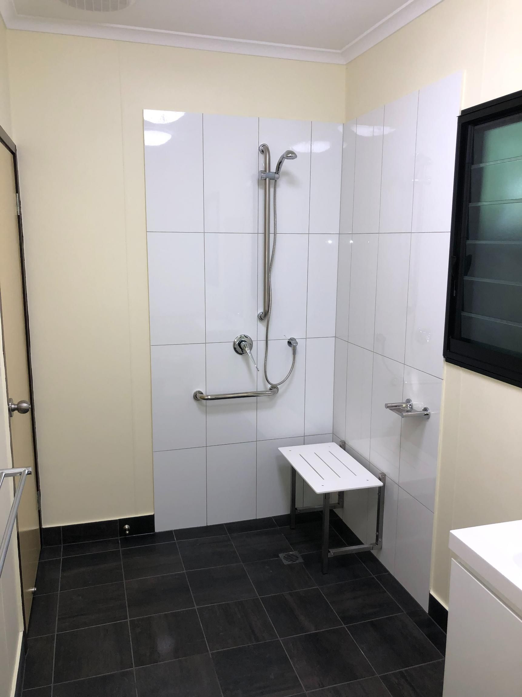 A Bathroom With a Walk in Shower and a Bench — New Home Builders in Yarrawonga, NT