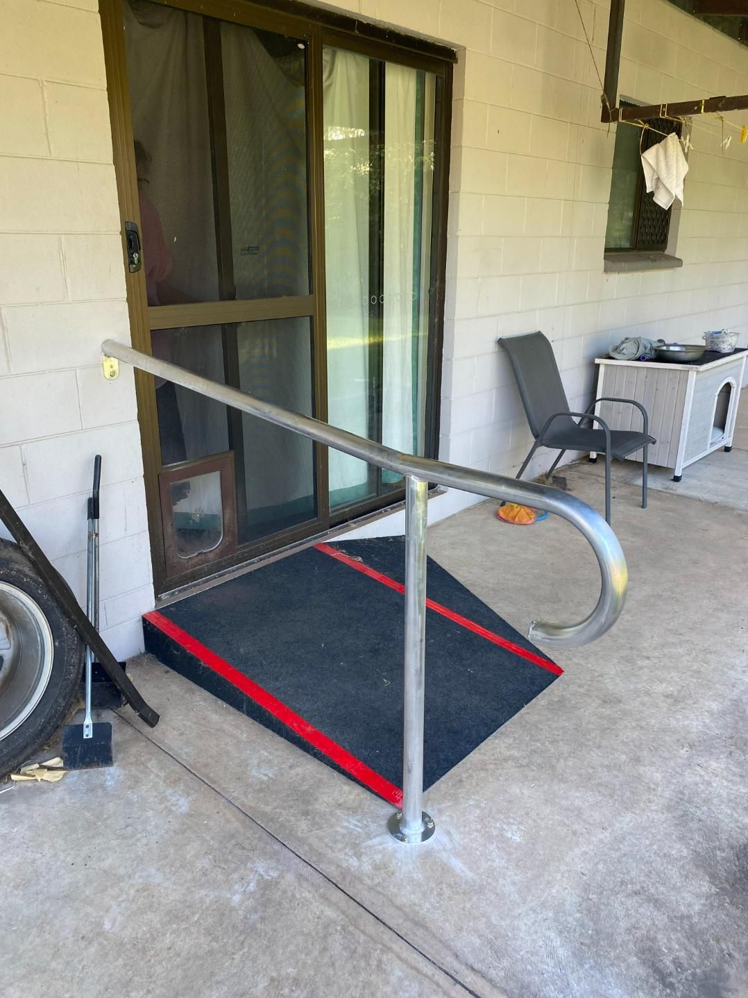 A Ramp is Sitting on the Side of a Porch Next to a Sliding Glass Door — Accessibility Renovations in Yarrawonga, NT