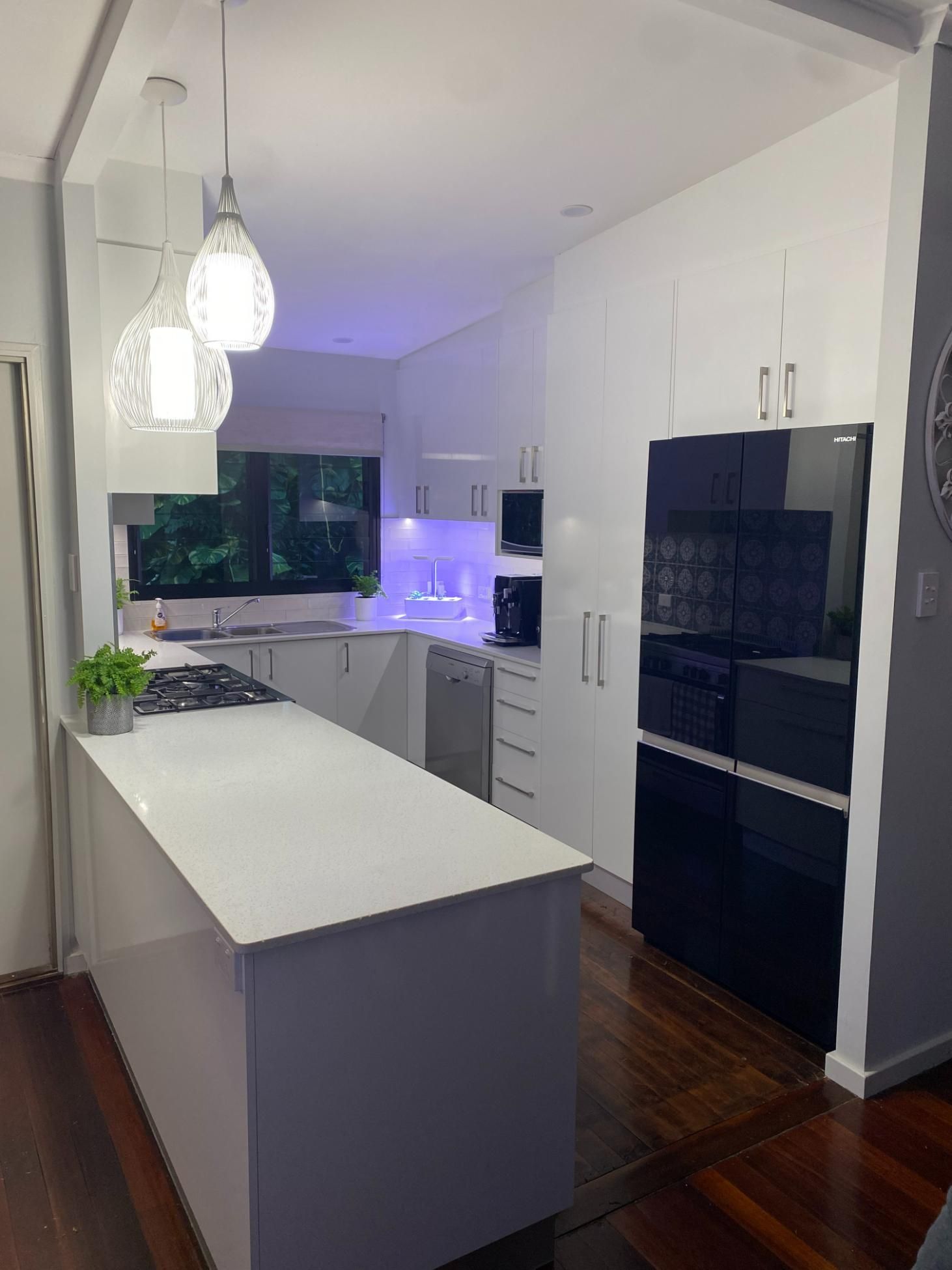 A Kitchen With White Cabinets and a Black Refrigerator — Renovations in Yarrawonga, NT