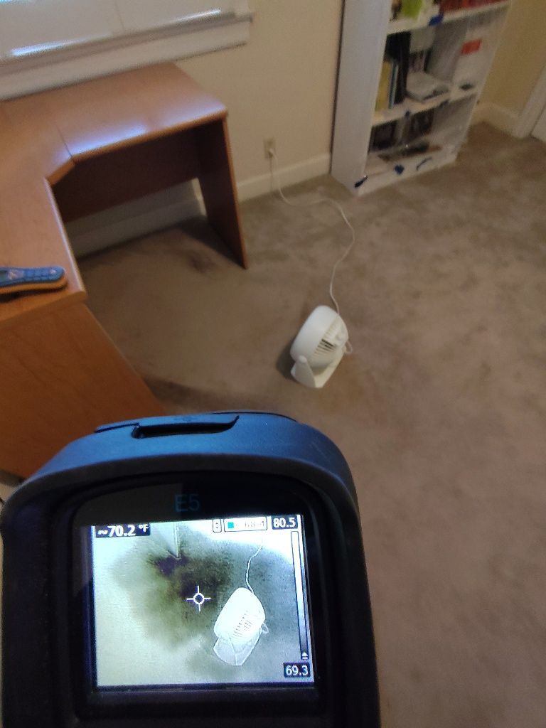 A thermometer in a room shows a temperature of 77 degrees