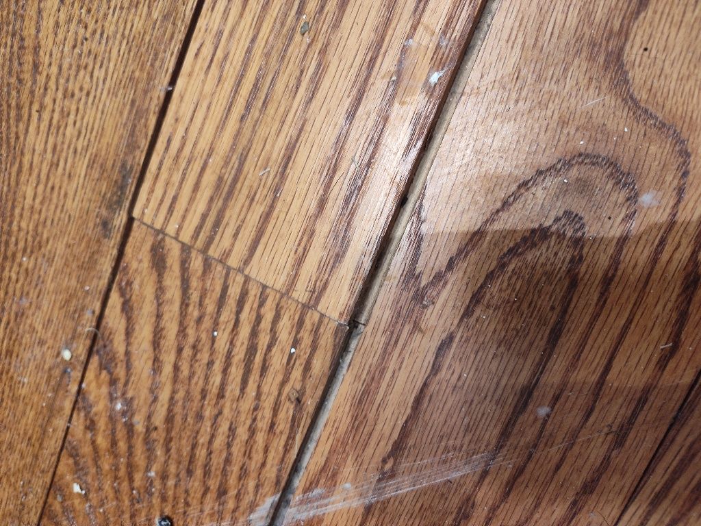 A close up of a wooden floor with a stain on it.