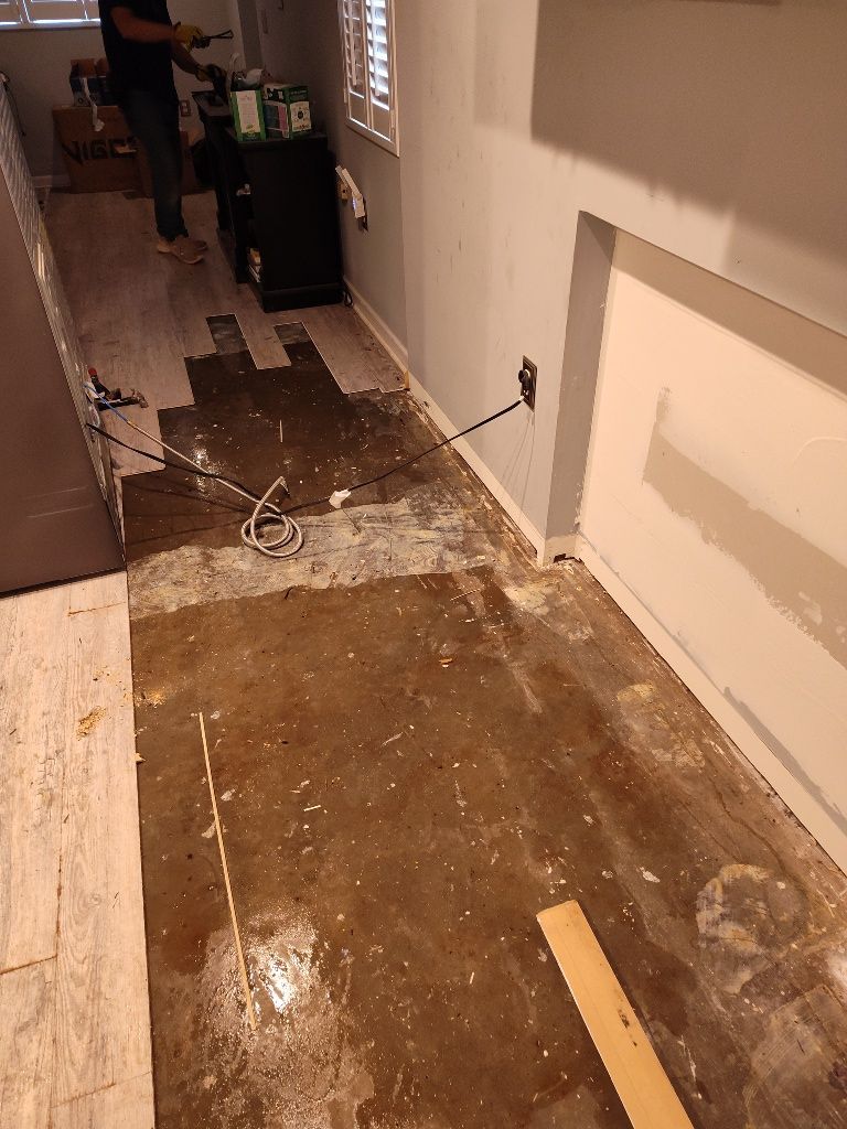A man is standing on a dirty floor in a room.
