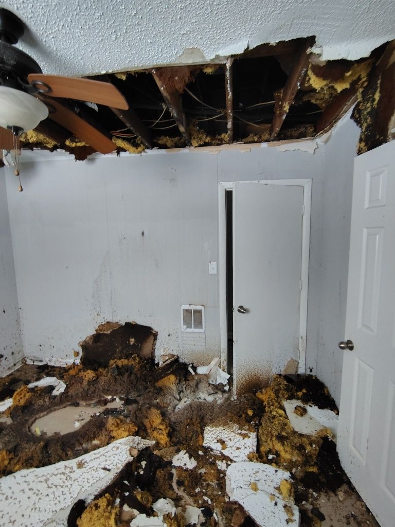 A room with a ceiling fan and a door.