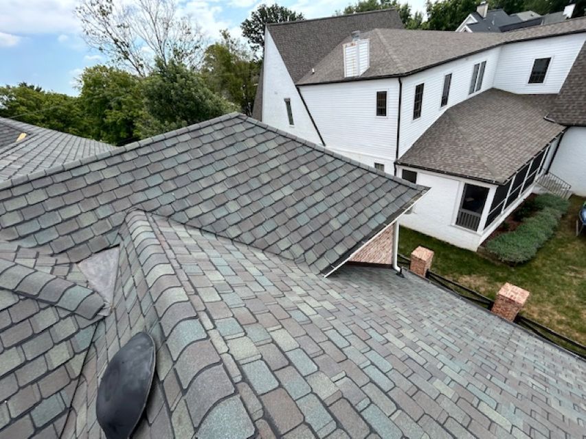 An aerial view of a large house with a roof that is covered in shingles.