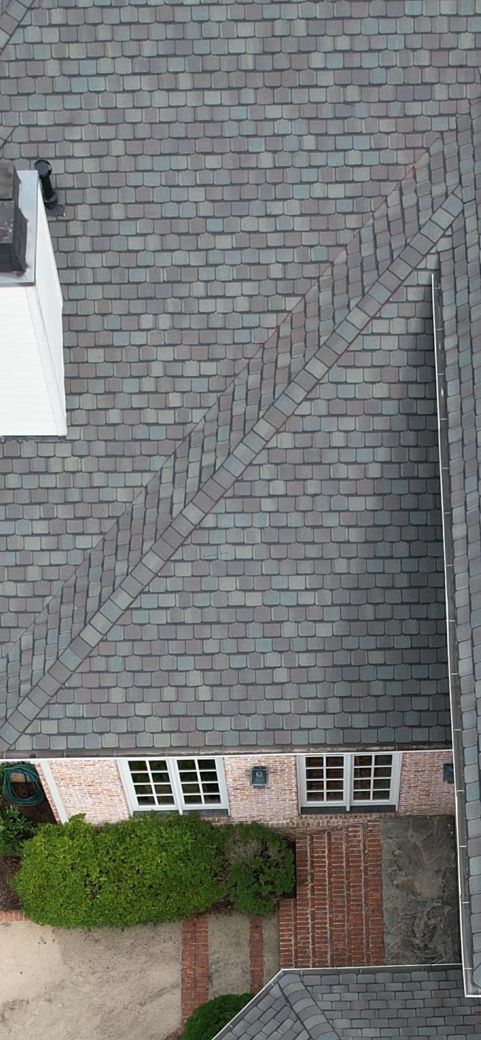 An aerial view of a house with a roof and a driveway.