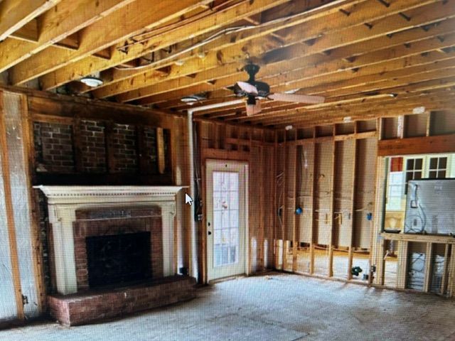 An empty room with a fireplace and a ceiling fan