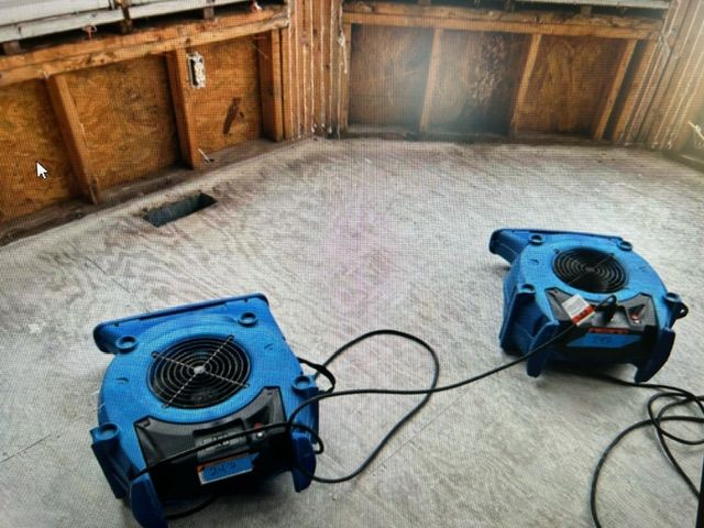 Two blue fans are sitting on the floor in a room.