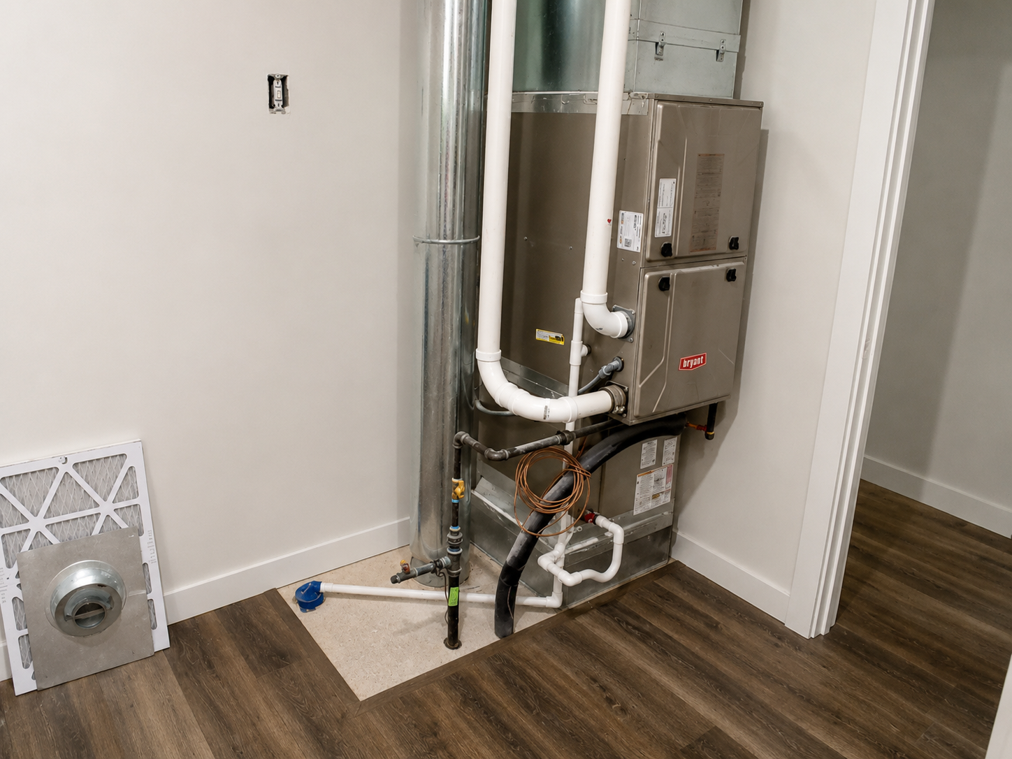 Narrow white louvered closet door between beige wall and brown door, with a washing machine on the right.