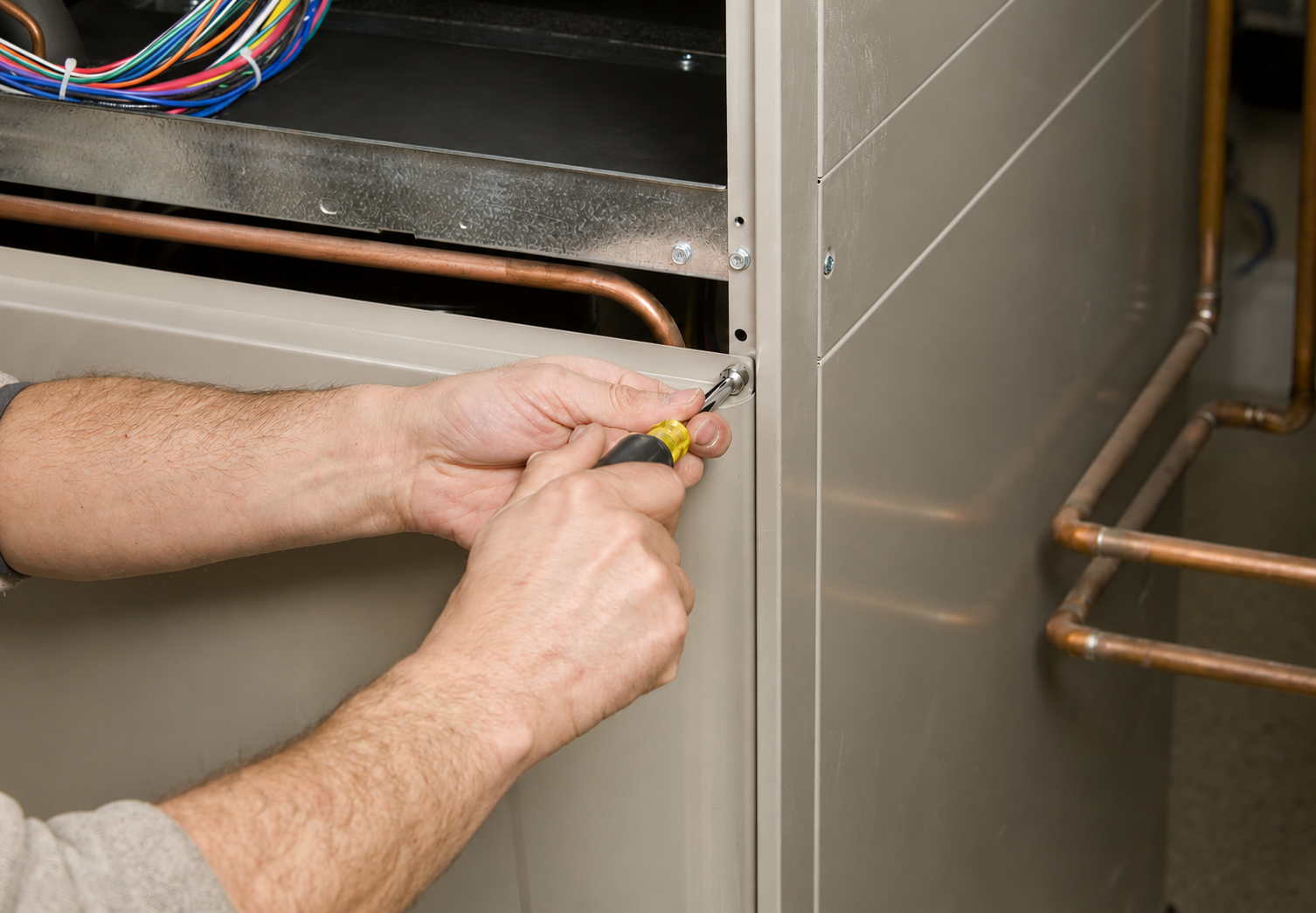 Gas furnace and ductwork in a basement utility room, with white PVC vent pipes.