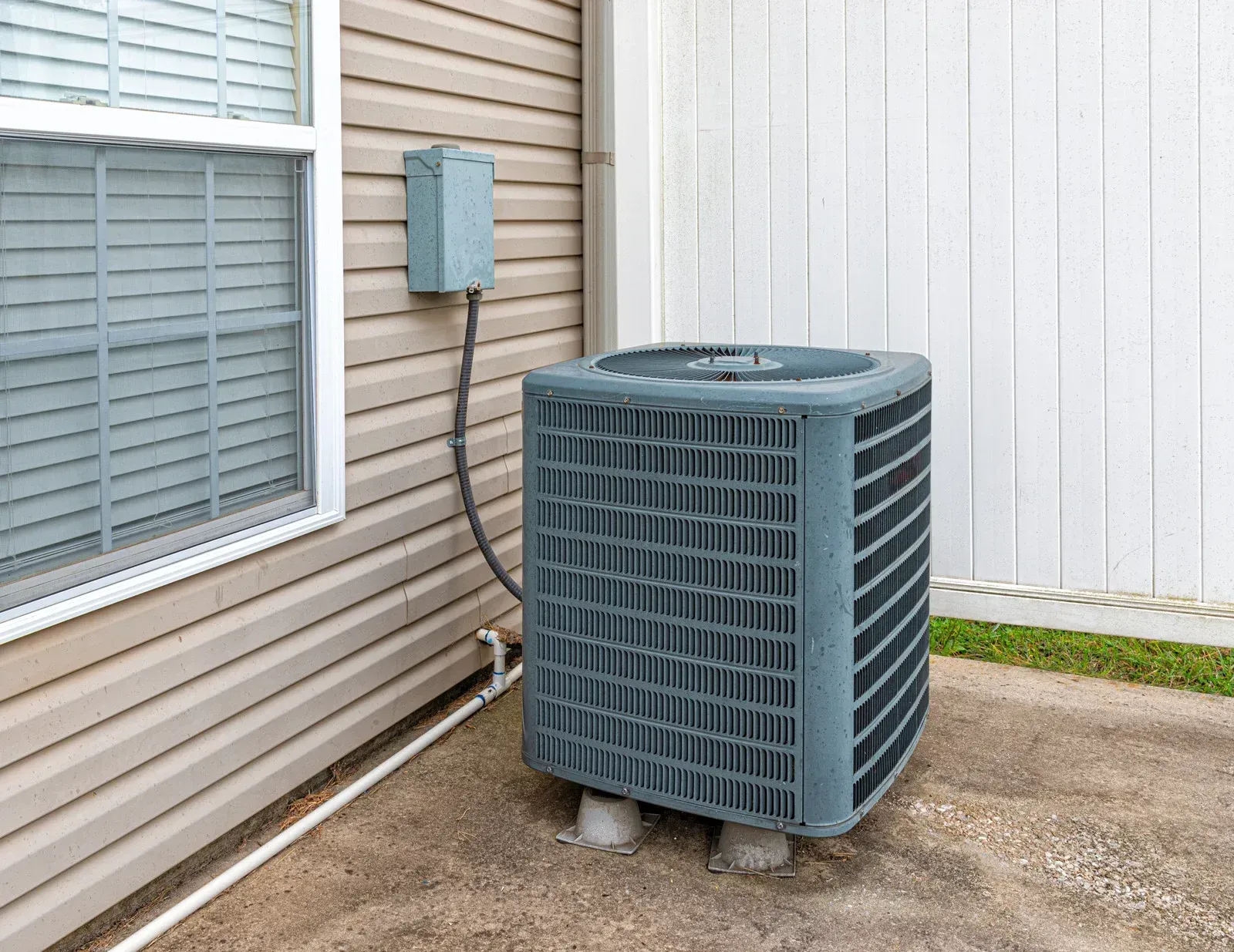 Roof-installed Carrier HVAC unit with a worker standing behind it on a flat rooftop.
