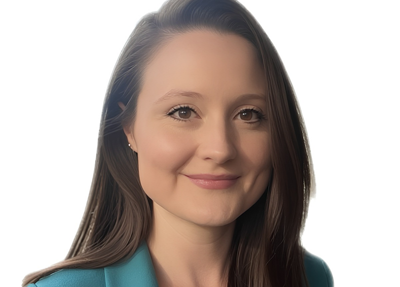Woman in a teal blazer smiling against a white background