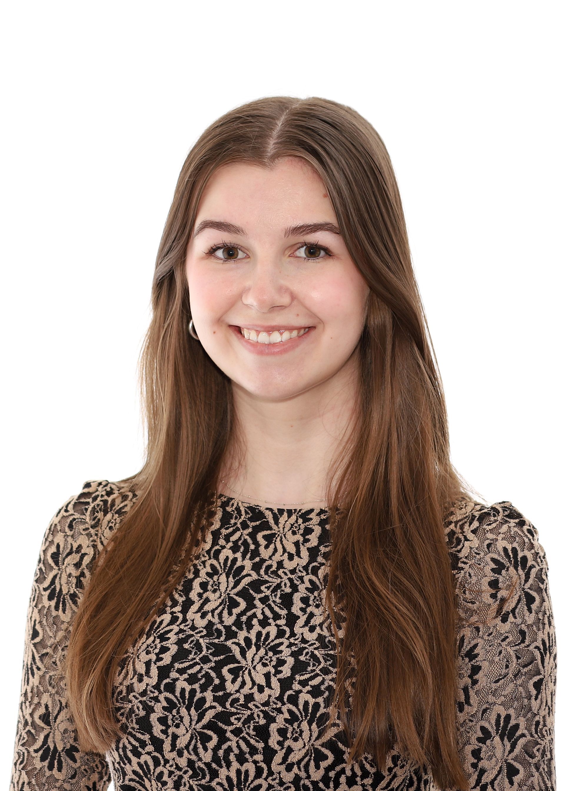 A young woman in a leopard print dress is smiling for the camera.