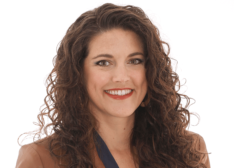 A woman with curly hair is smiling for the camera.