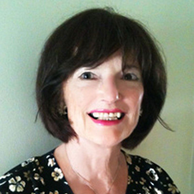 A woman with short brown hair is smiling for the camera