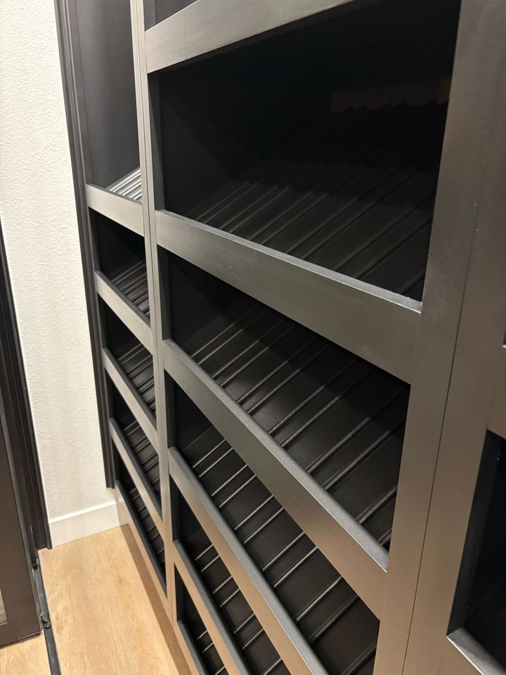 Black empty shelving unit in a narrow hallway or closet