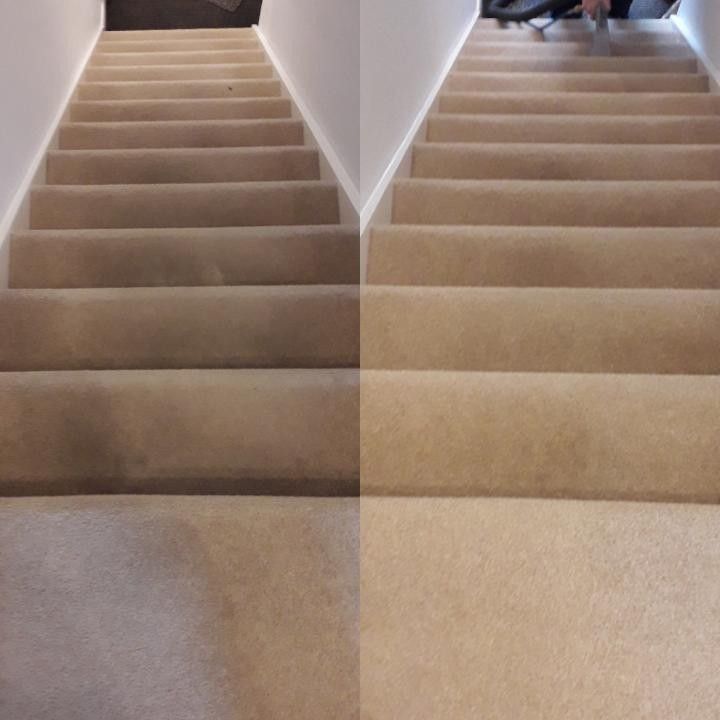 Carpeted staircase with a central landing, viewed from the bottom up