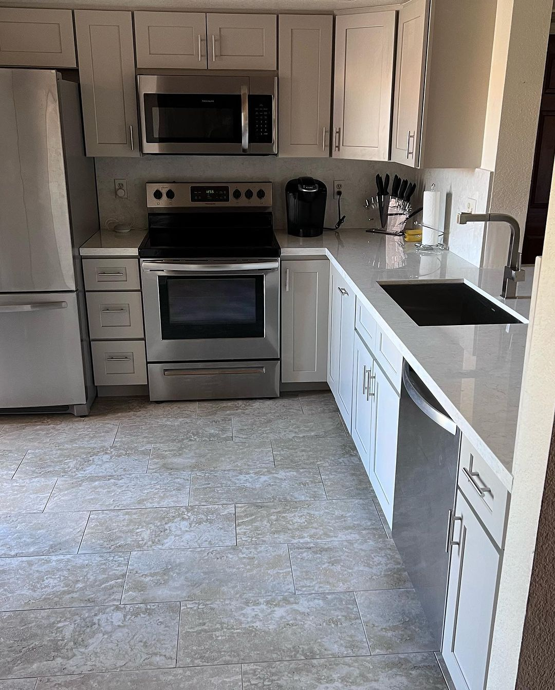 A kitchen with stainless steel appliances and white cabinets