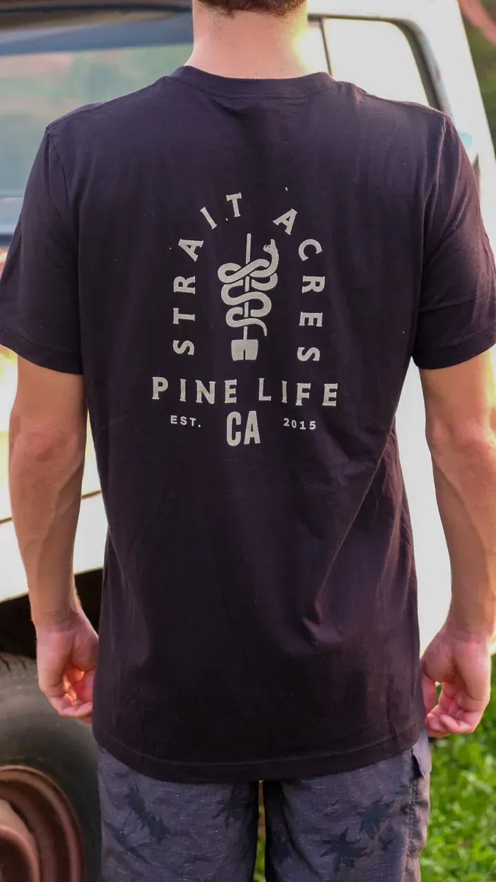 A person wearing a black t-shirt with a white graphic on the back that says