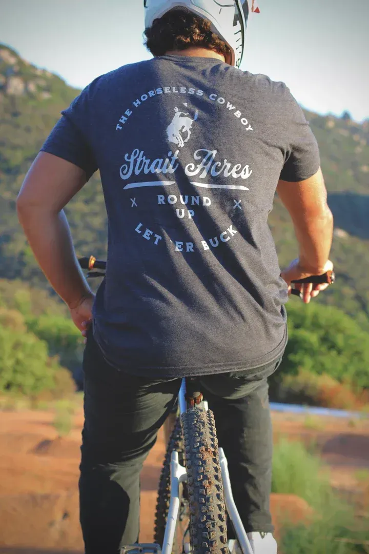 Person riding a mountain bike, wearing a dark t-shirt with