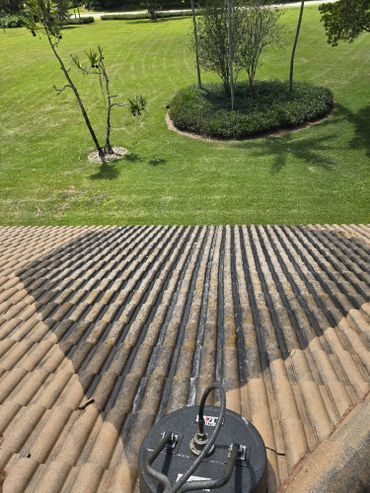 The roof of a house is being cleaned with a machine.