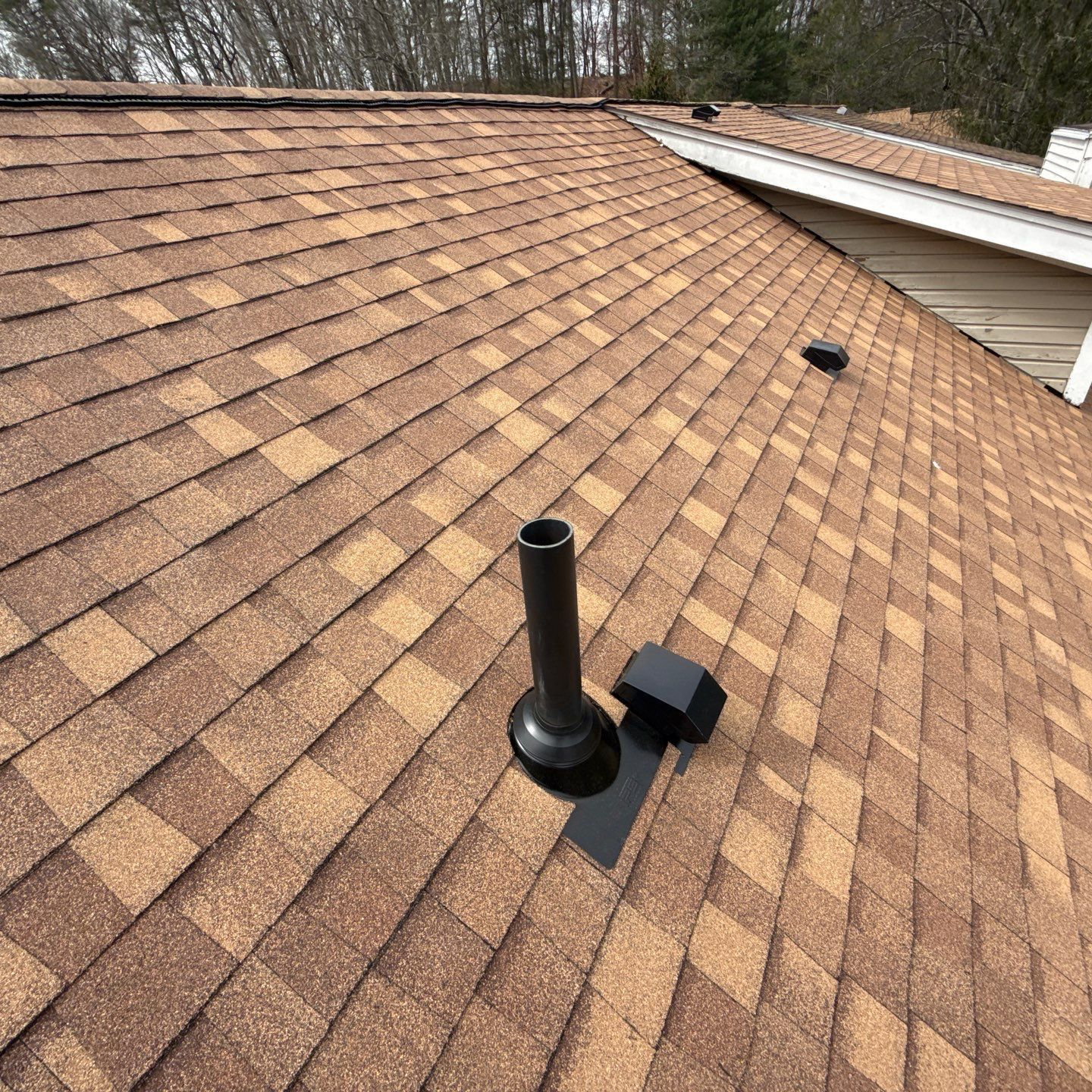 A close up of a roof with shingles and a gutter.