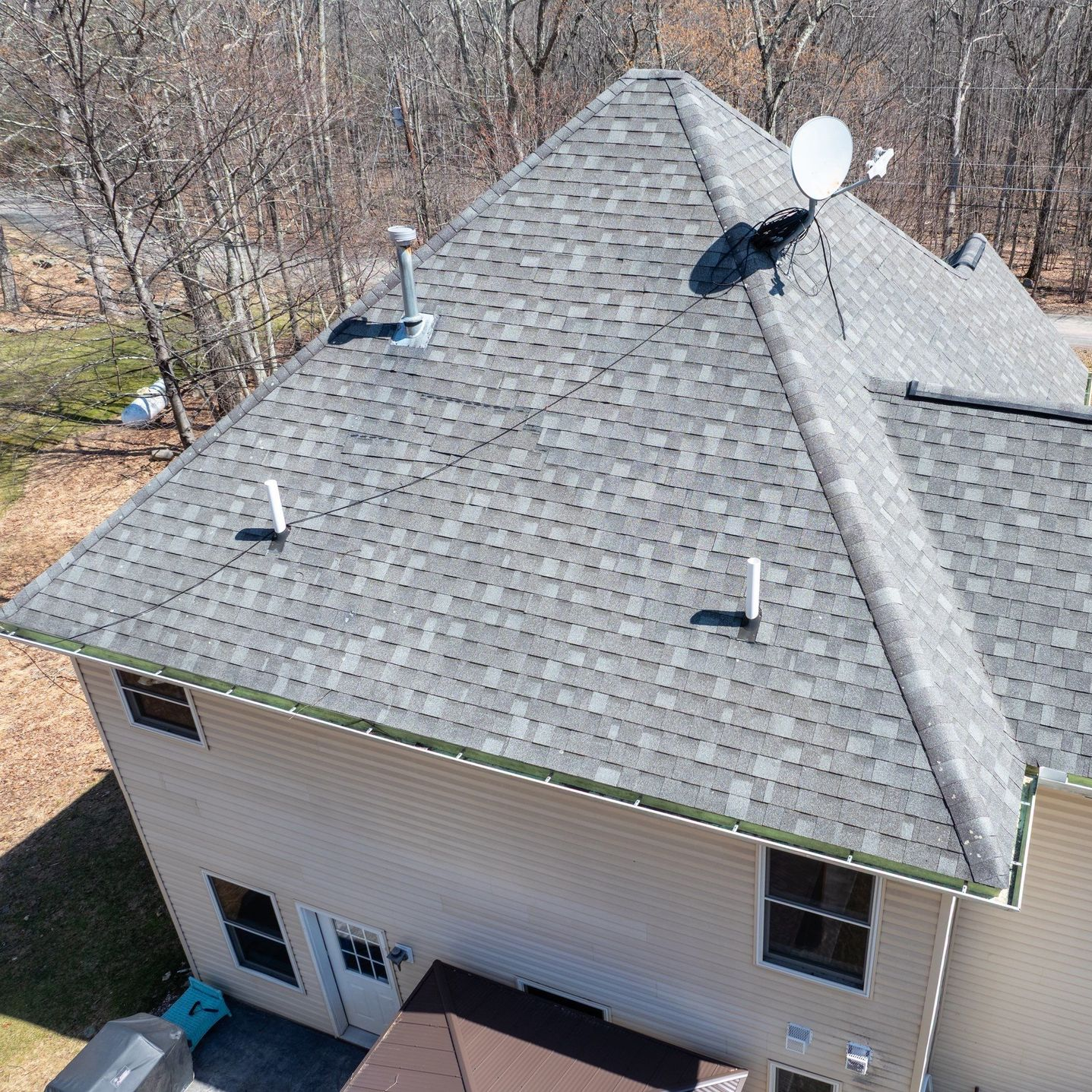A person is holding a hammer in front of a roof