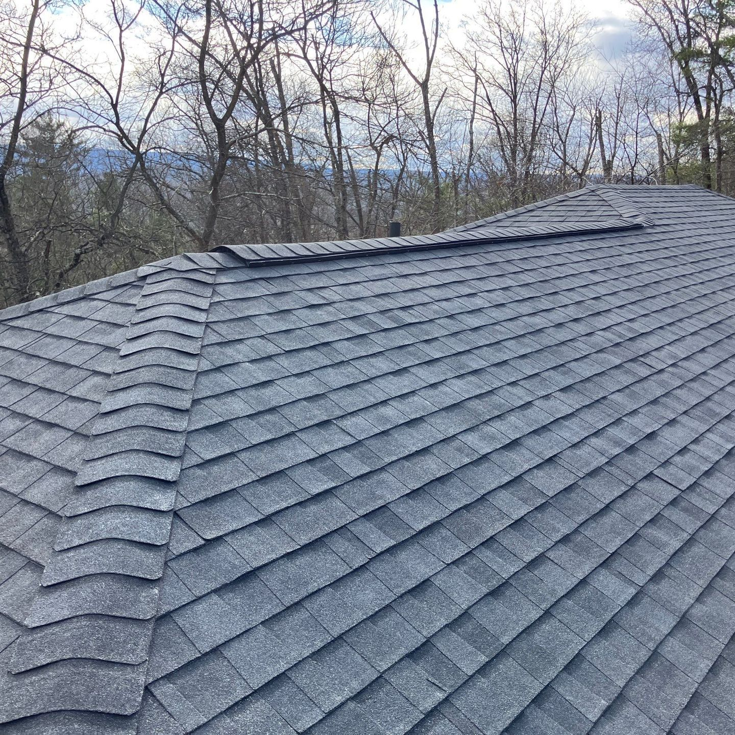 A close up of a roof with shingles and a gutter. A close up of a roof with shingles and a gutter.