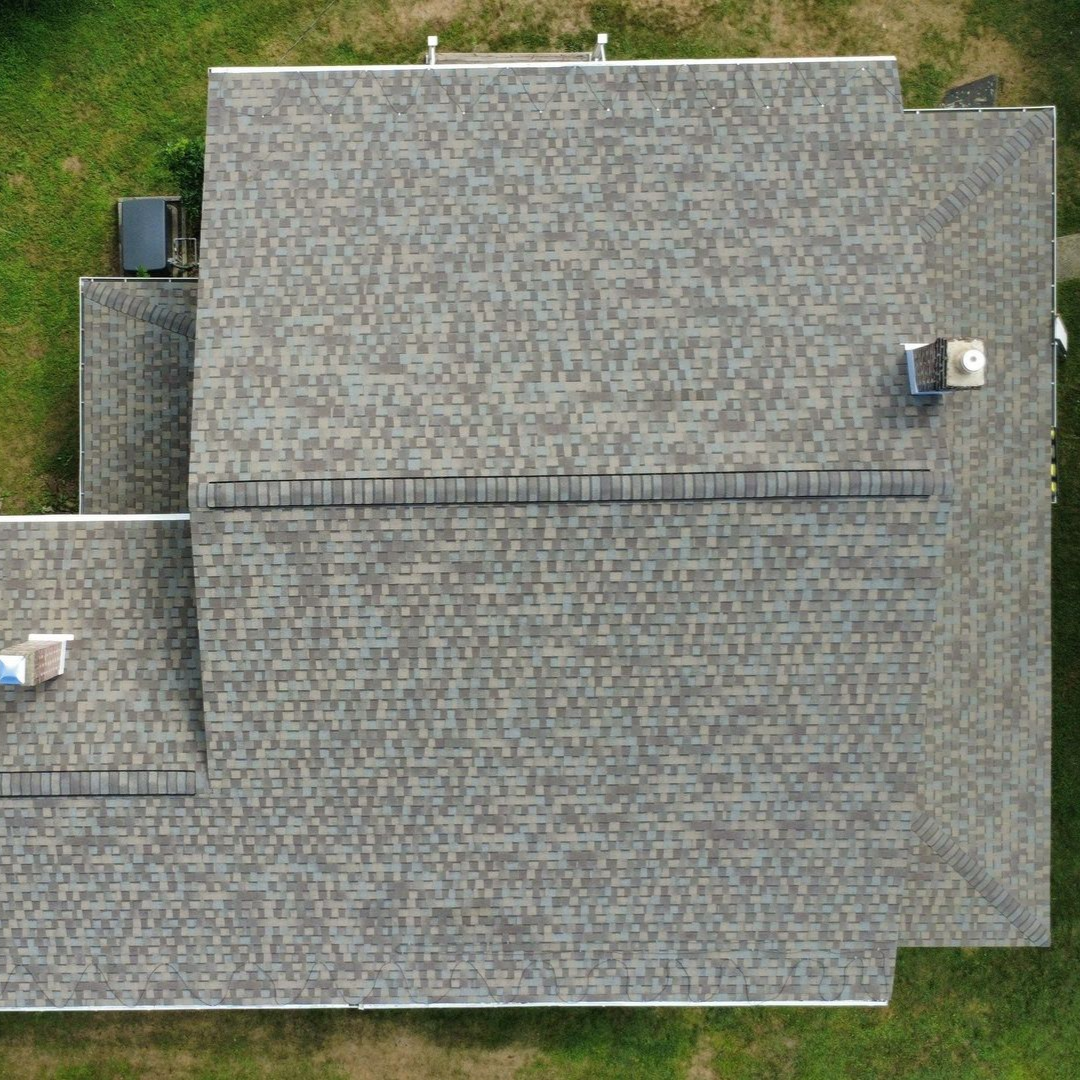 A close up of a roof with shingles and a gutter.