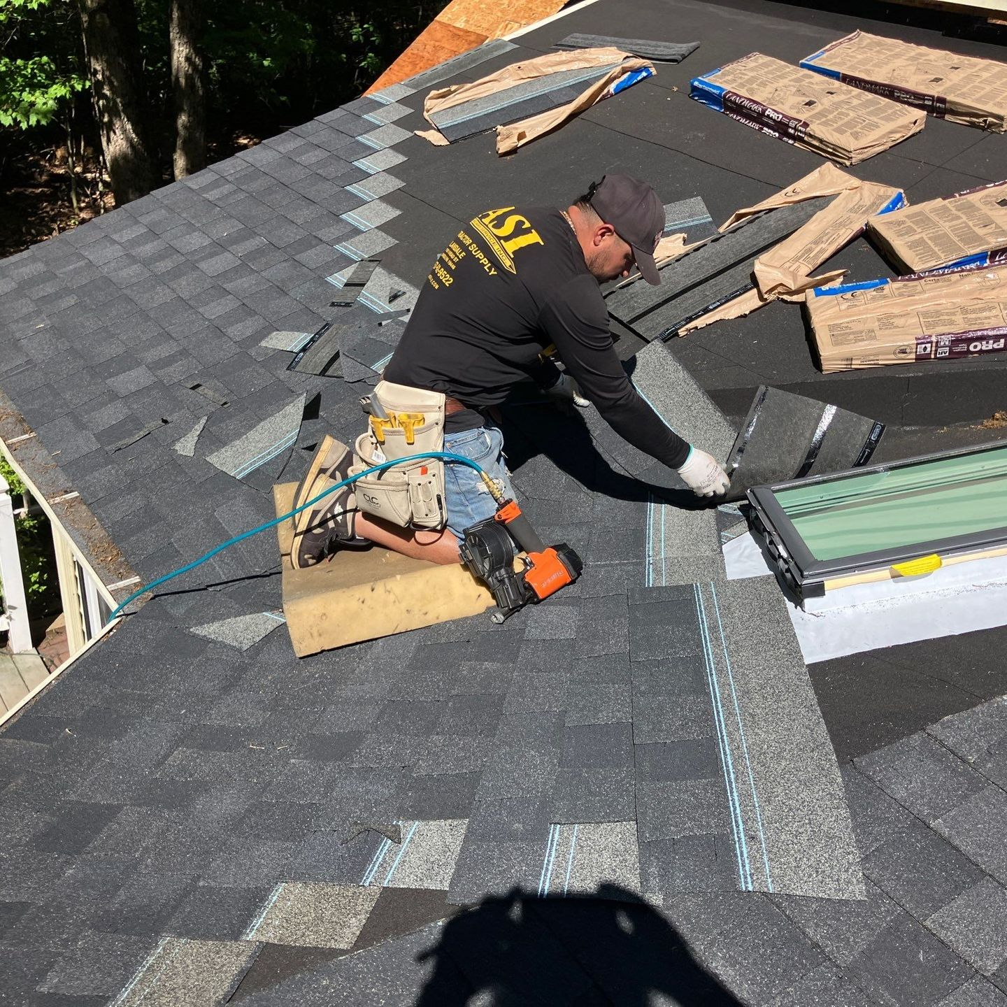 A person is holding a hammer in front of a roof A person is holding a hammer in front of a roof