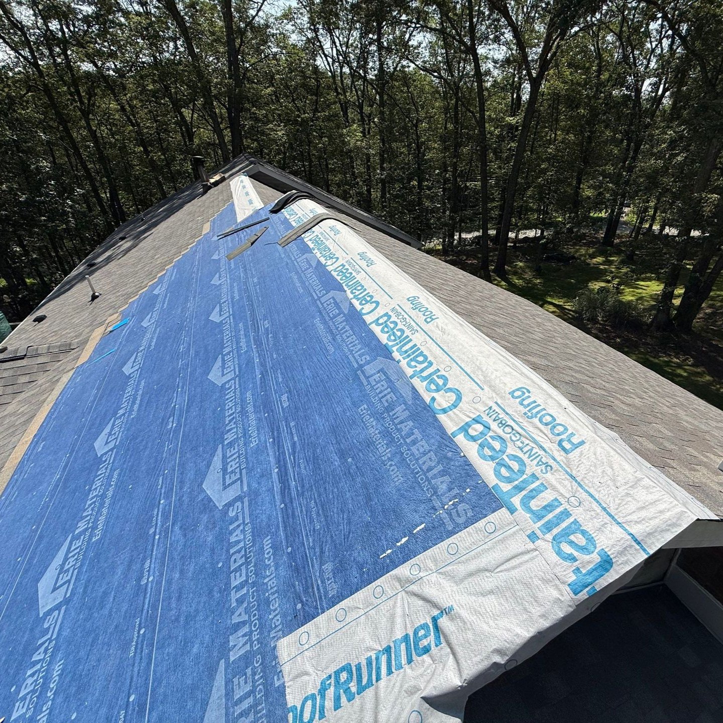 A person is fixing a roof with a drill
