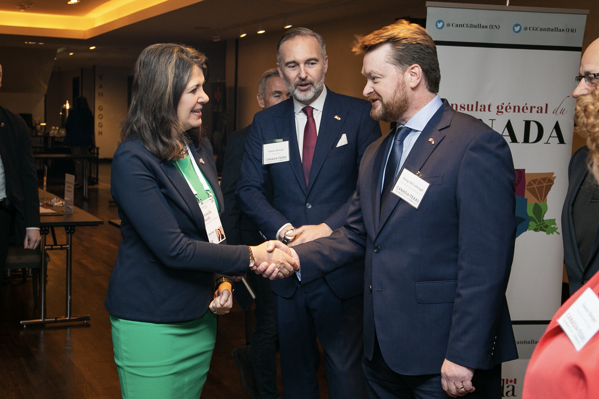 A group of people are shaking hands in a room.