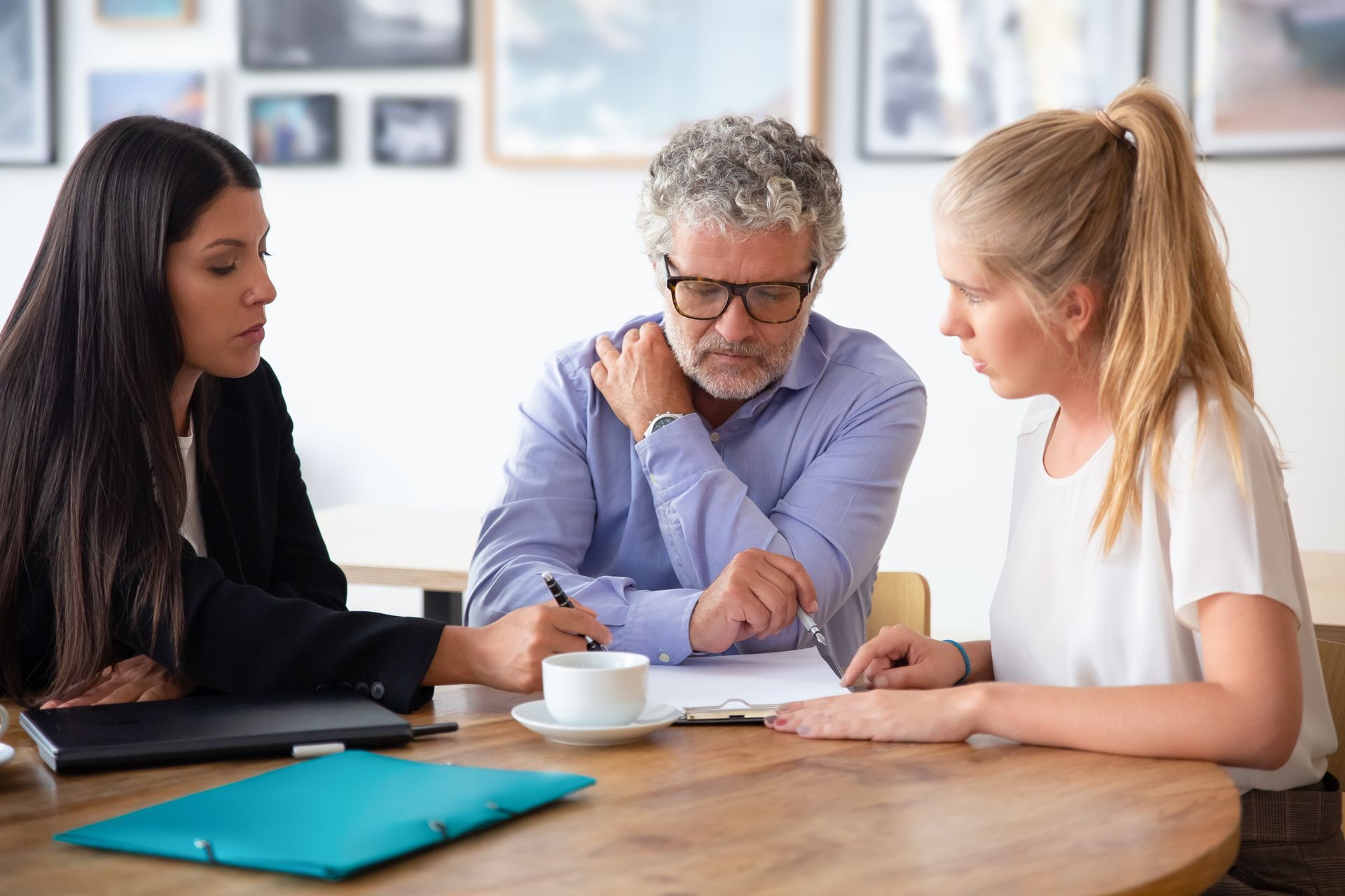 A family law attorney reviewing custody paperwork with two clients during a consultation