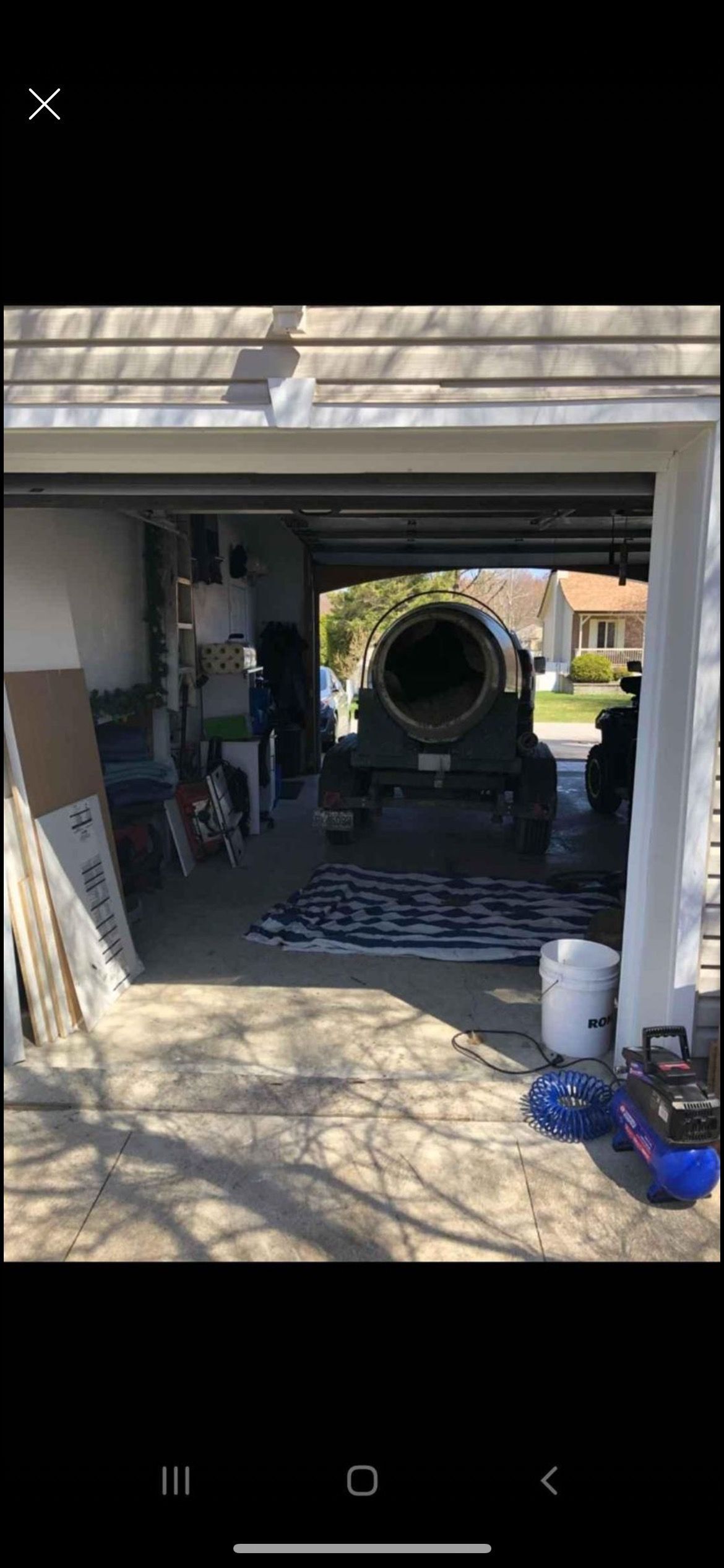 Une grande bétonnière se trouve dans un garage.