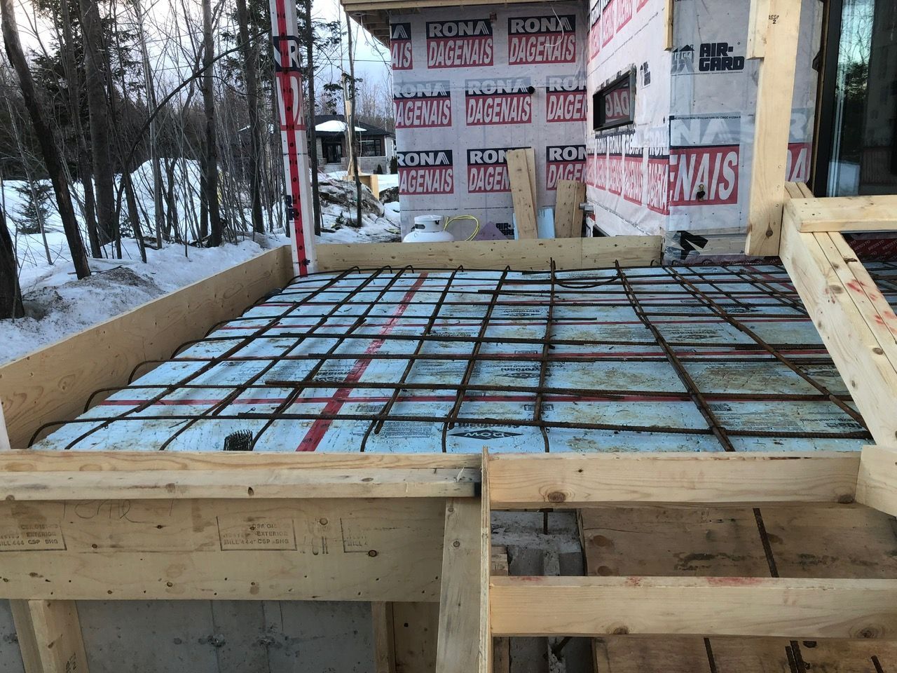Un sol en béton est en cours de construction devant un immeuble.