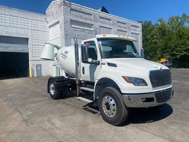 Un camion-citerne blanc est garé devant un immeuble.