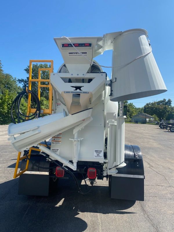 Un camion malaxeur à béton est garé dans un parking